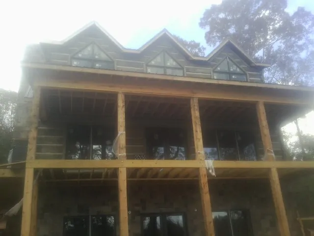 Dormers and porch framing on a large log home under construction — Roof Coating work by our crew in Cupertino