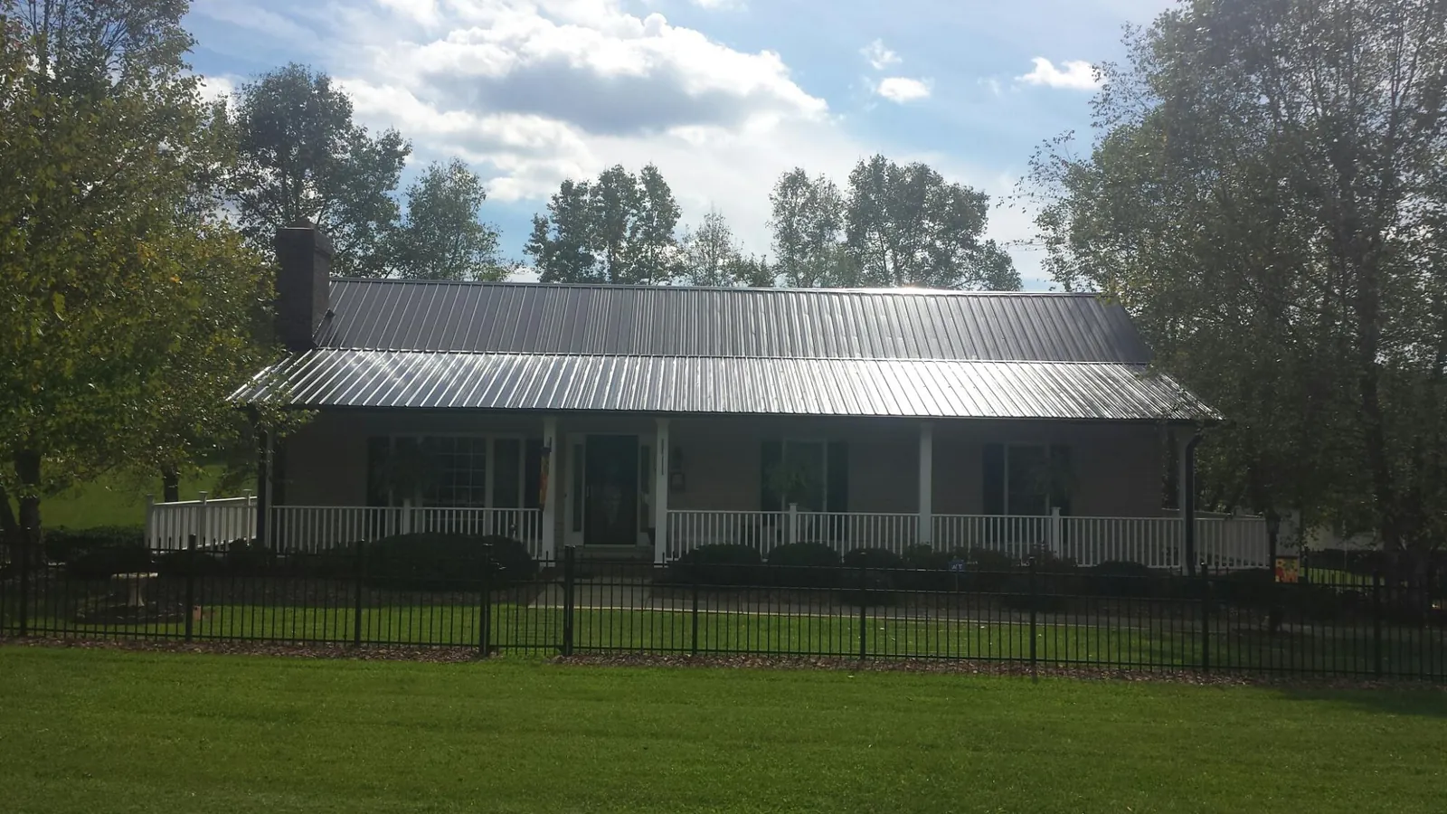 Gray metal roof on a brick ranch with a full width front porch — Gutter Guard Installation work by our crew in Cupertino